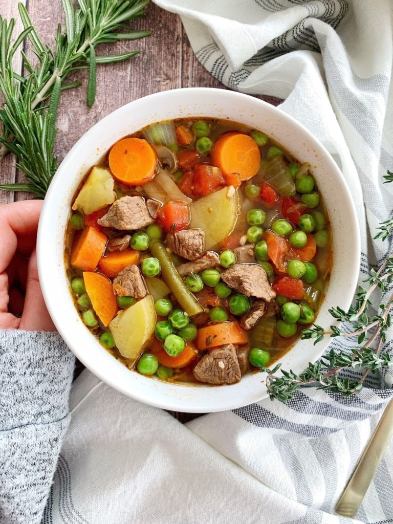 A bowl of Instant Pot beef vegetable soup with rosemary and thyme.