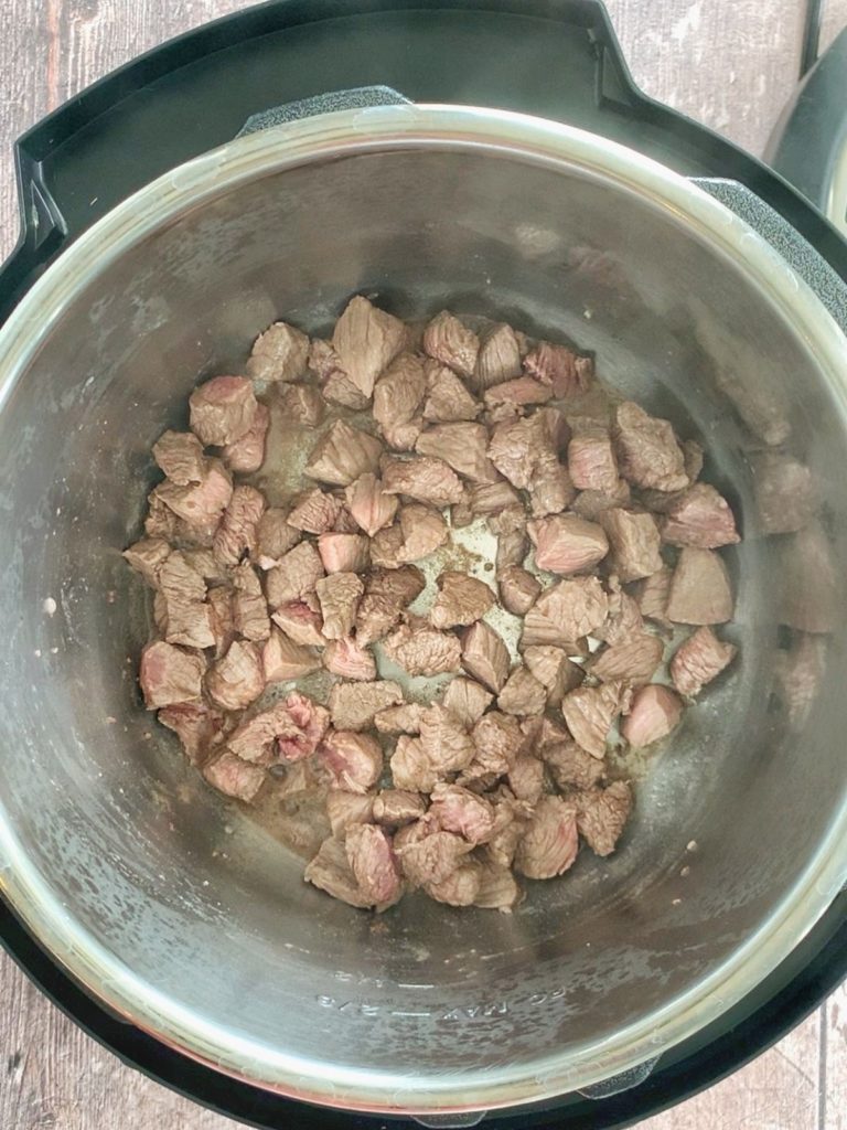 Stew meat being browned in the bowl of an Instant Pot