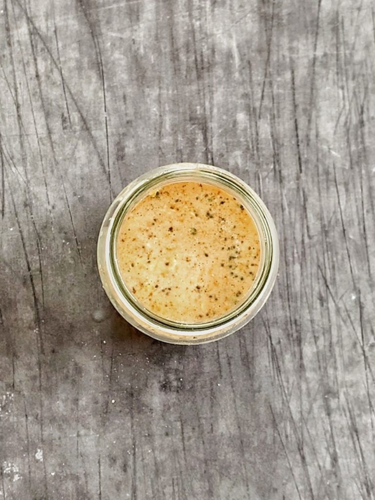 A glass jar of protein overnight oats after stirring everything together.