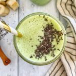 A low-carb green smoothie topped with chia seeds and a straw.