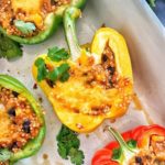 A yellow bell pepper stuffed with quinoa and topped with cheese.
