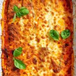 A pan of zucchini lasagna with ground turkey and basil.