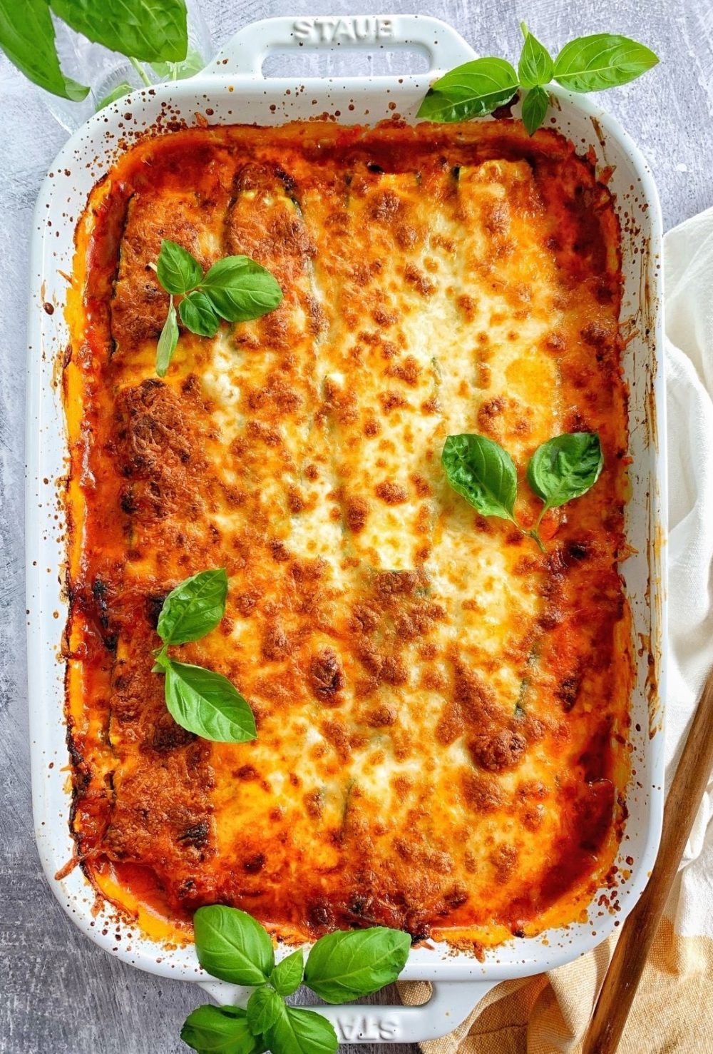 A pan of zucchini lasagna with ground turkey and basil.