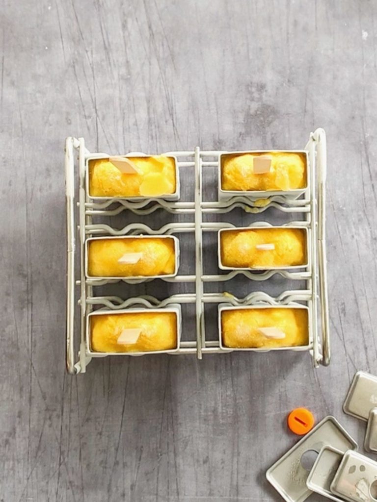 Frozen mango popsicles in their popsicle molds.