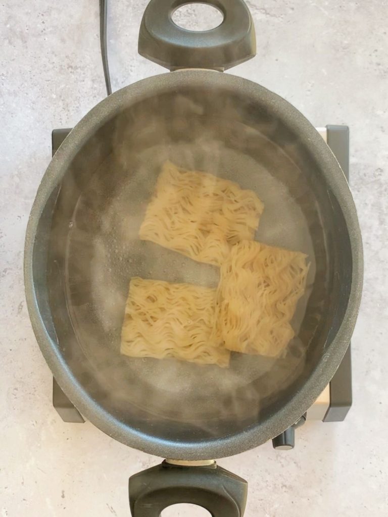Ramen noodles in a pot of hot water.