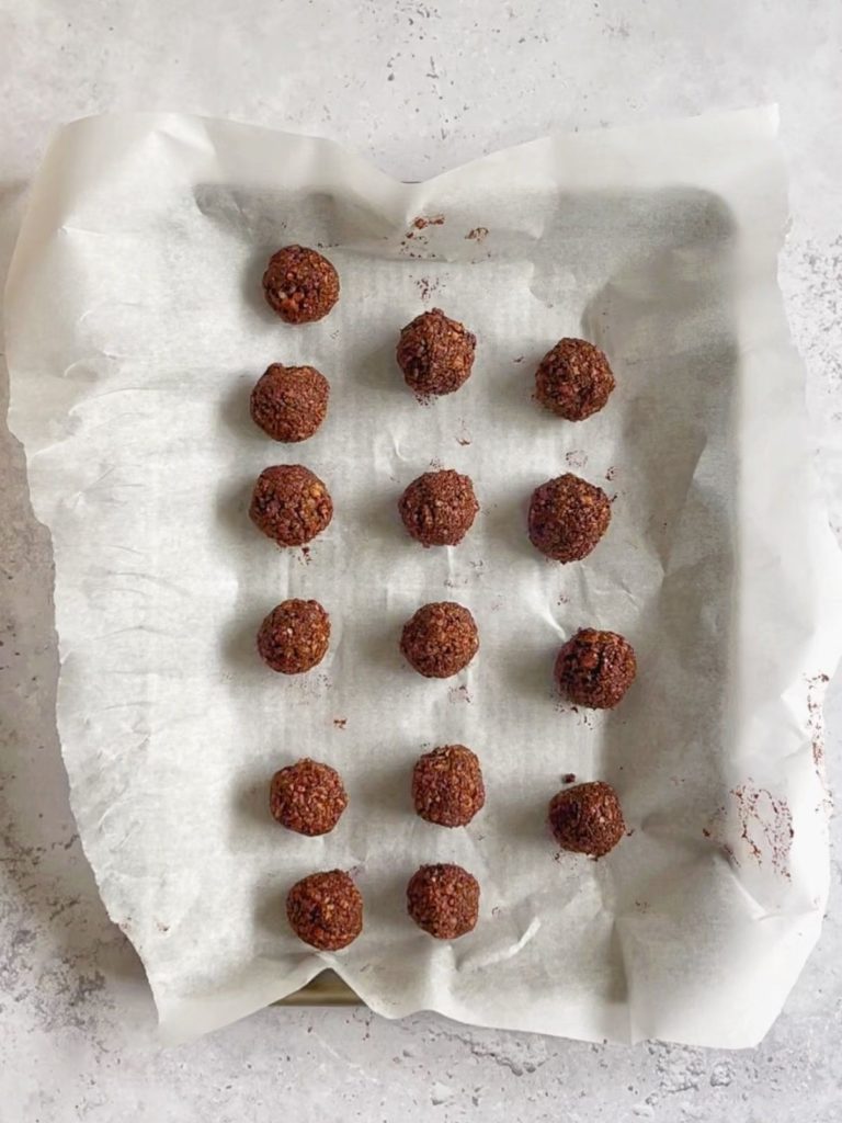 Chocolate hazelnut energy balls on a sheet pan.