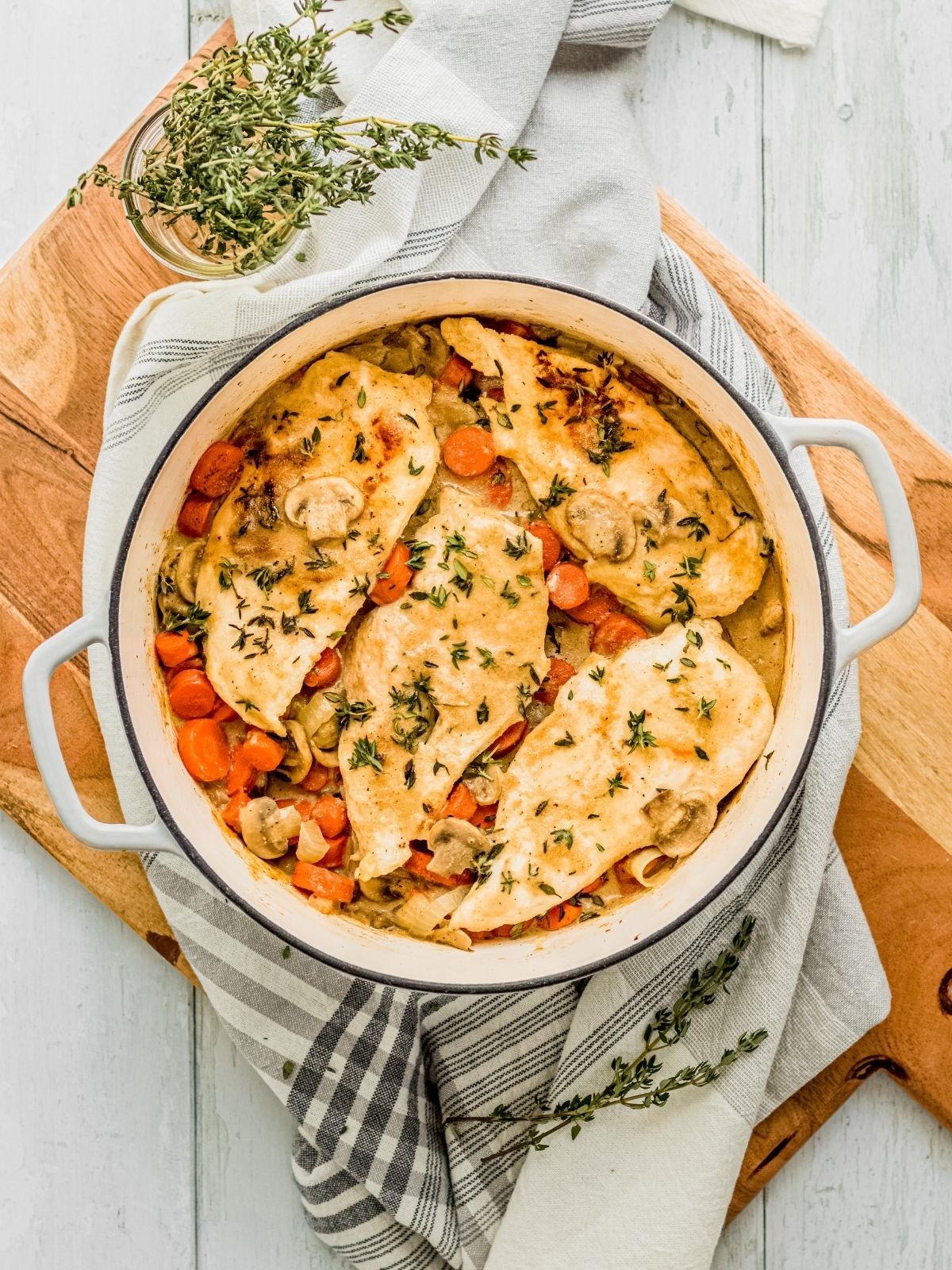 A dutch oven full of chicken breast and vegetables.