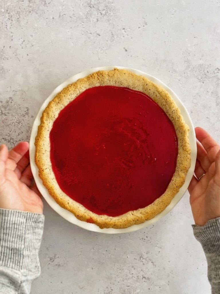 The fresh cranberry layer poured on top of the custard layer in the pie pan.