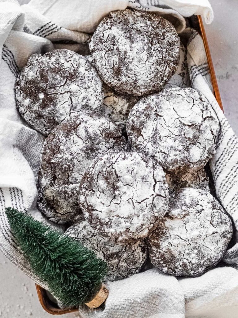 A cookie tin full of chocolate crinkle cookies.