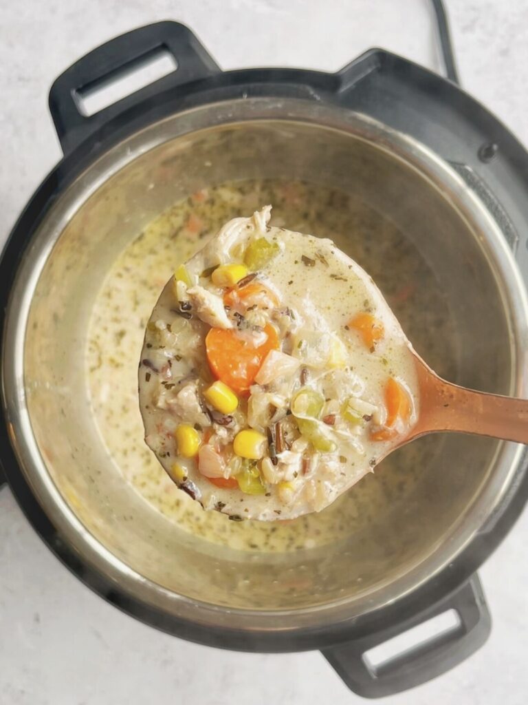 A ladle full of Instant Pot chicken and rice soup.