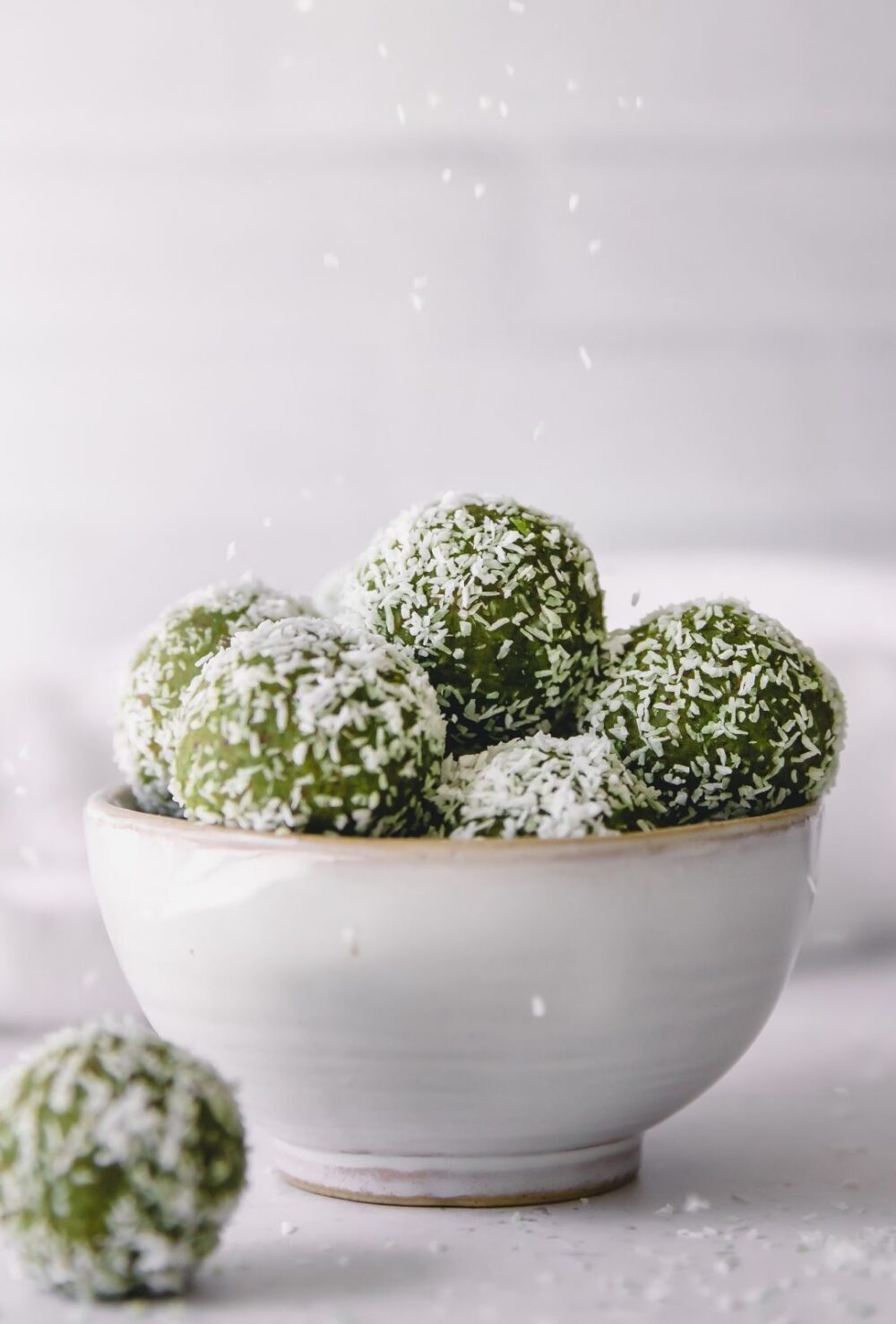 A bowl of coconut matcha protein balls.