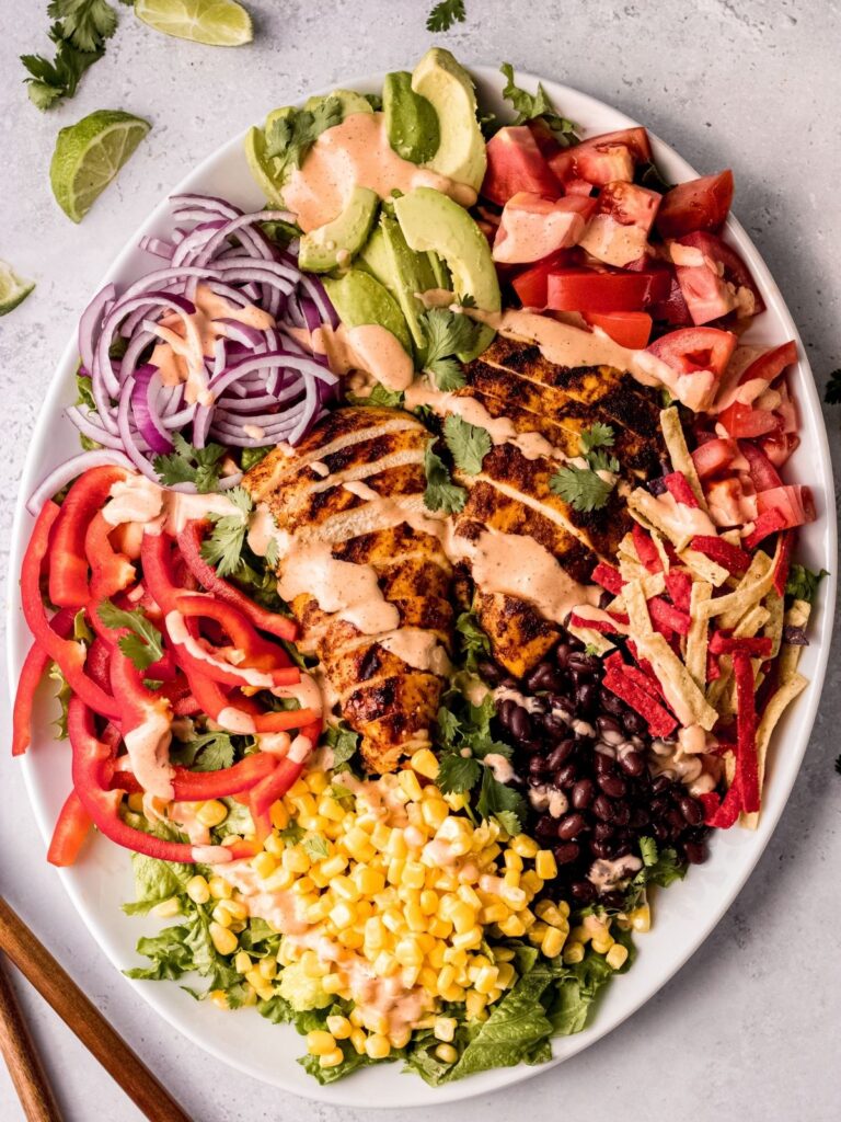 A spicy southwest chicken salad on a platter drizzled with southwest ranch dressing.