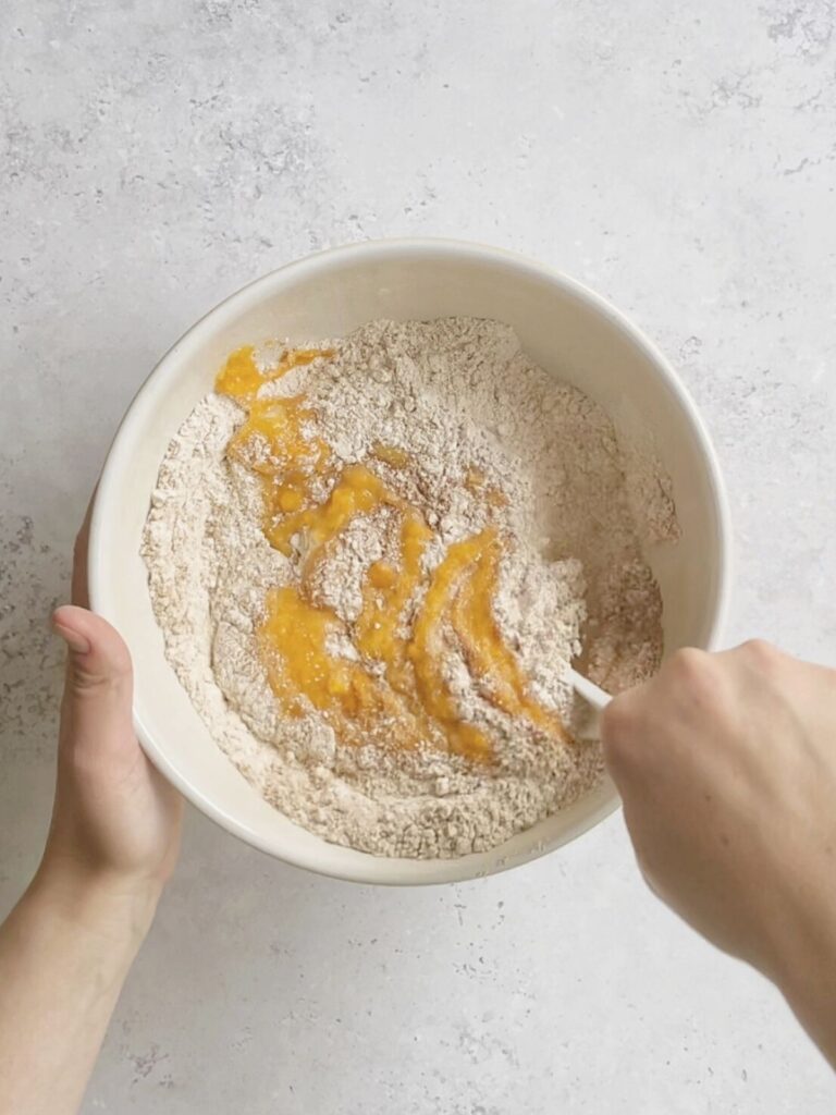 The butternut squash being mixed in with the dry ingredients.