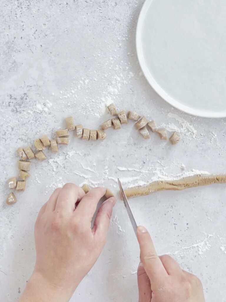 cutting a thin snake of boba dough into individual pearls