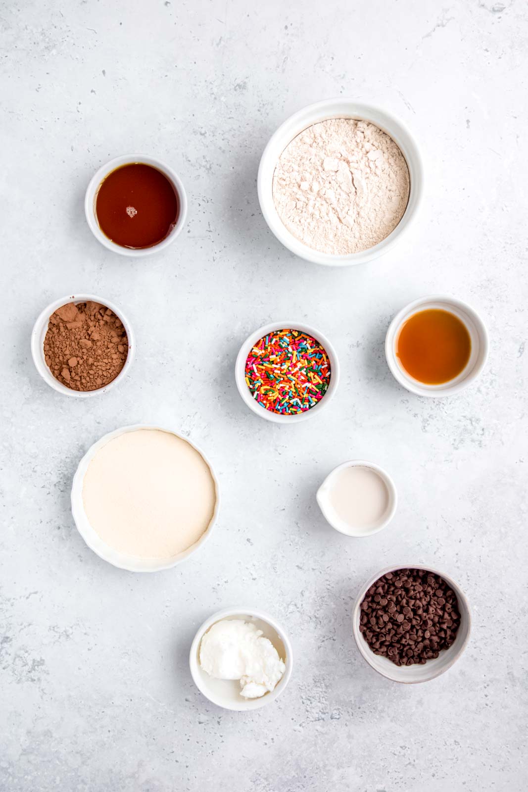 ingredients needed for making protein cookie dough 3 ways measured out into bowls on a table.