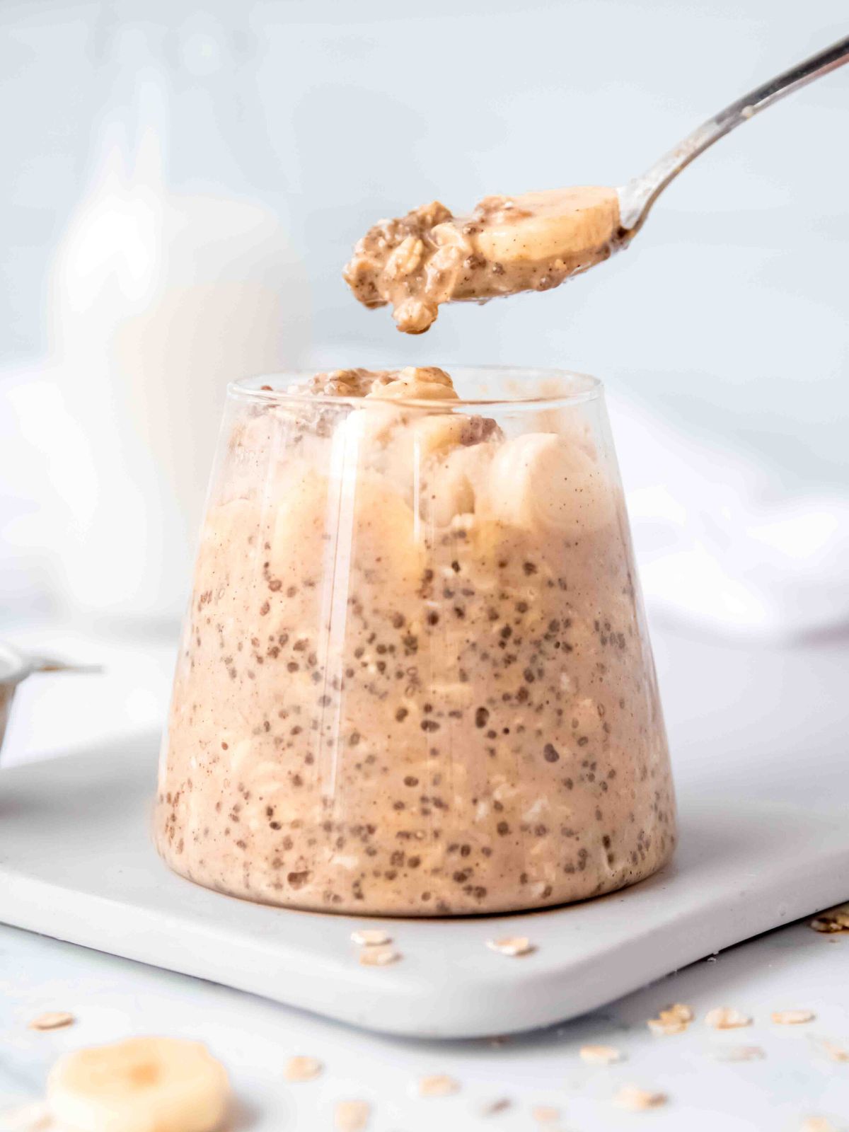 spoonful of protein overnight oats with a slice of banana being removed from the jar.