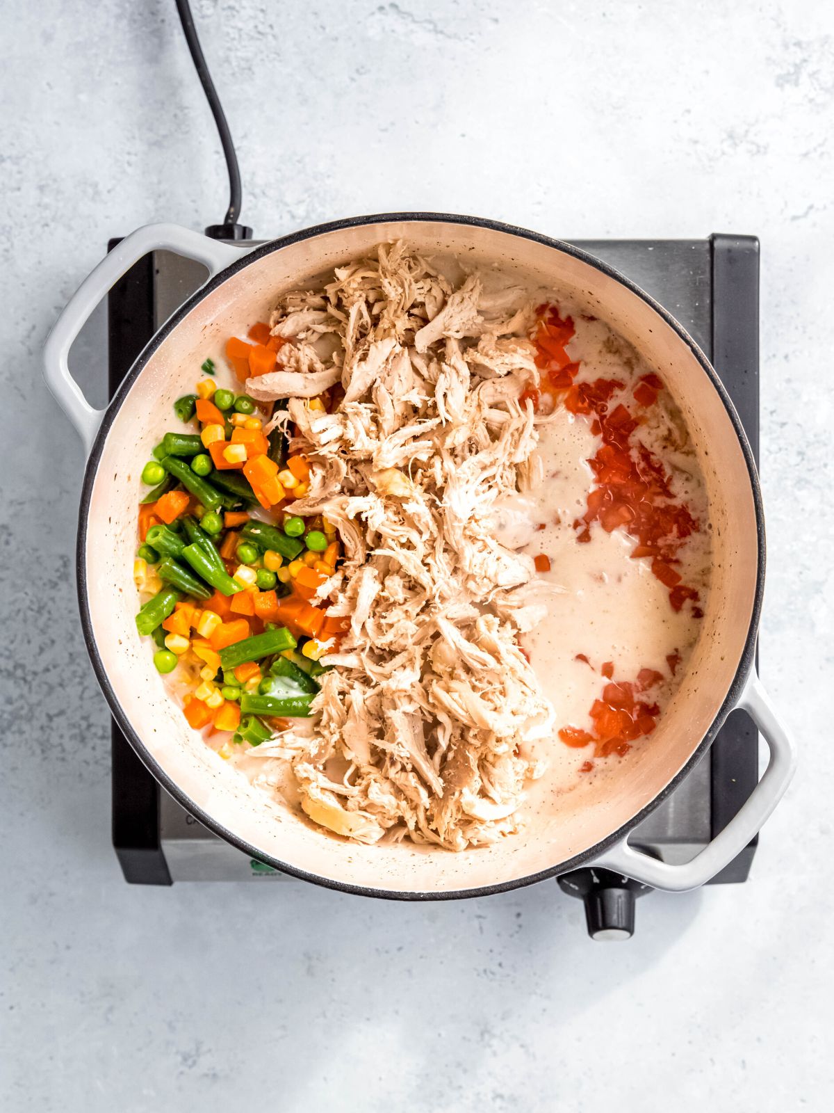shredded chicken, mixed veggies, and pimentos added to the dutch oven with the creamy white sauce.