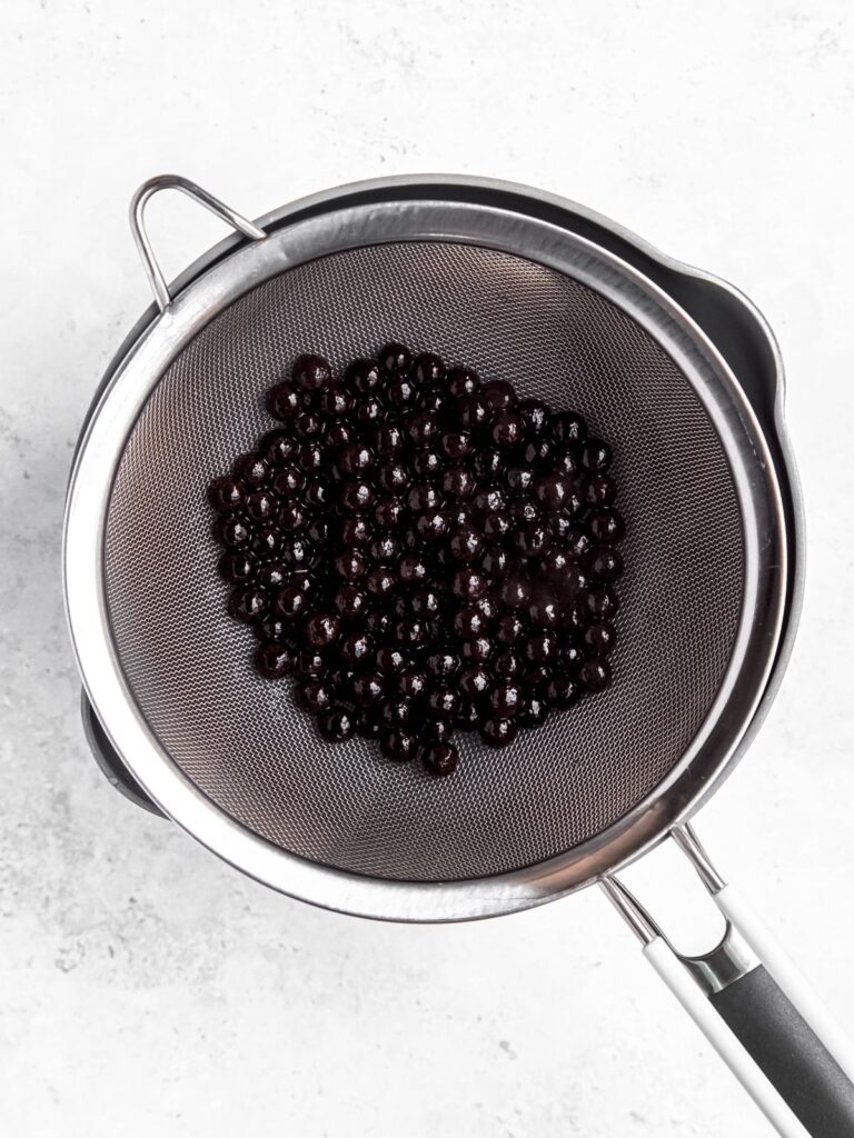 cooked boba pearls that have been rinsed and drained in a mesh strainer.