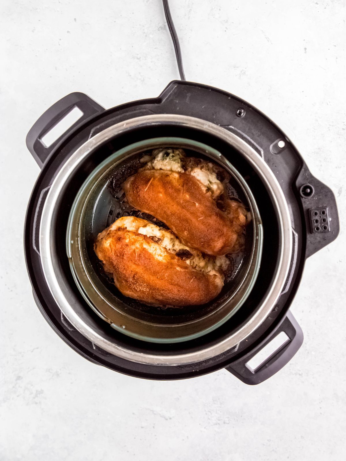 air fried stuffed chicken breasts in the base of the air fryer.