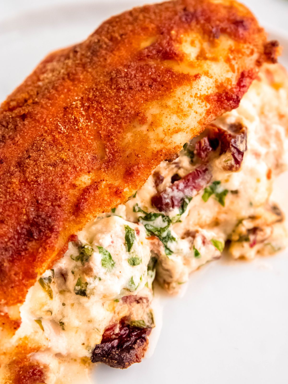 super closeup image of the air fried stuffed chicken breast on a white plate.