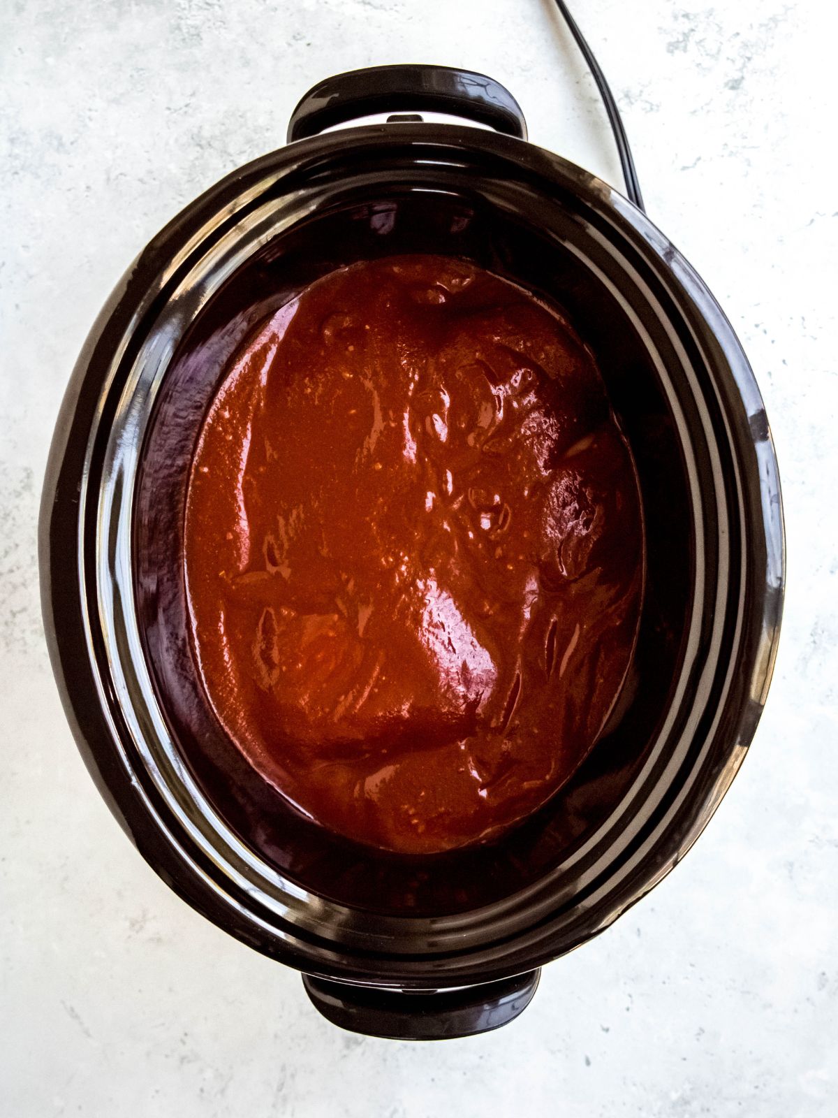 homemade enchilada sauce poured over the raw chicken breasts.