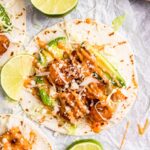 square hero image of spicy air fryer shrimp taco garnished with a drizzle of bang bang sauce and dusting of cotija cheese.