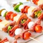 square hero of charcuterie skewers on a serving platter.