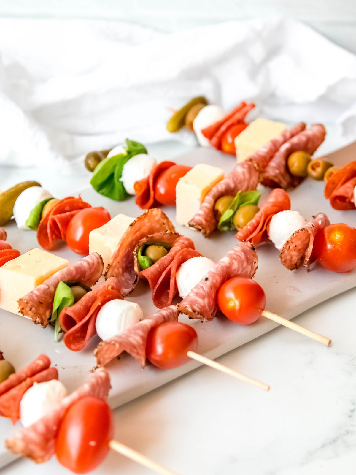 a table with a serving platter of charcuterie skewers ready to grab and eat.