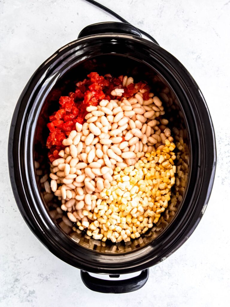 broth, tomatoes, beans, and corn added to slow cooker insert.