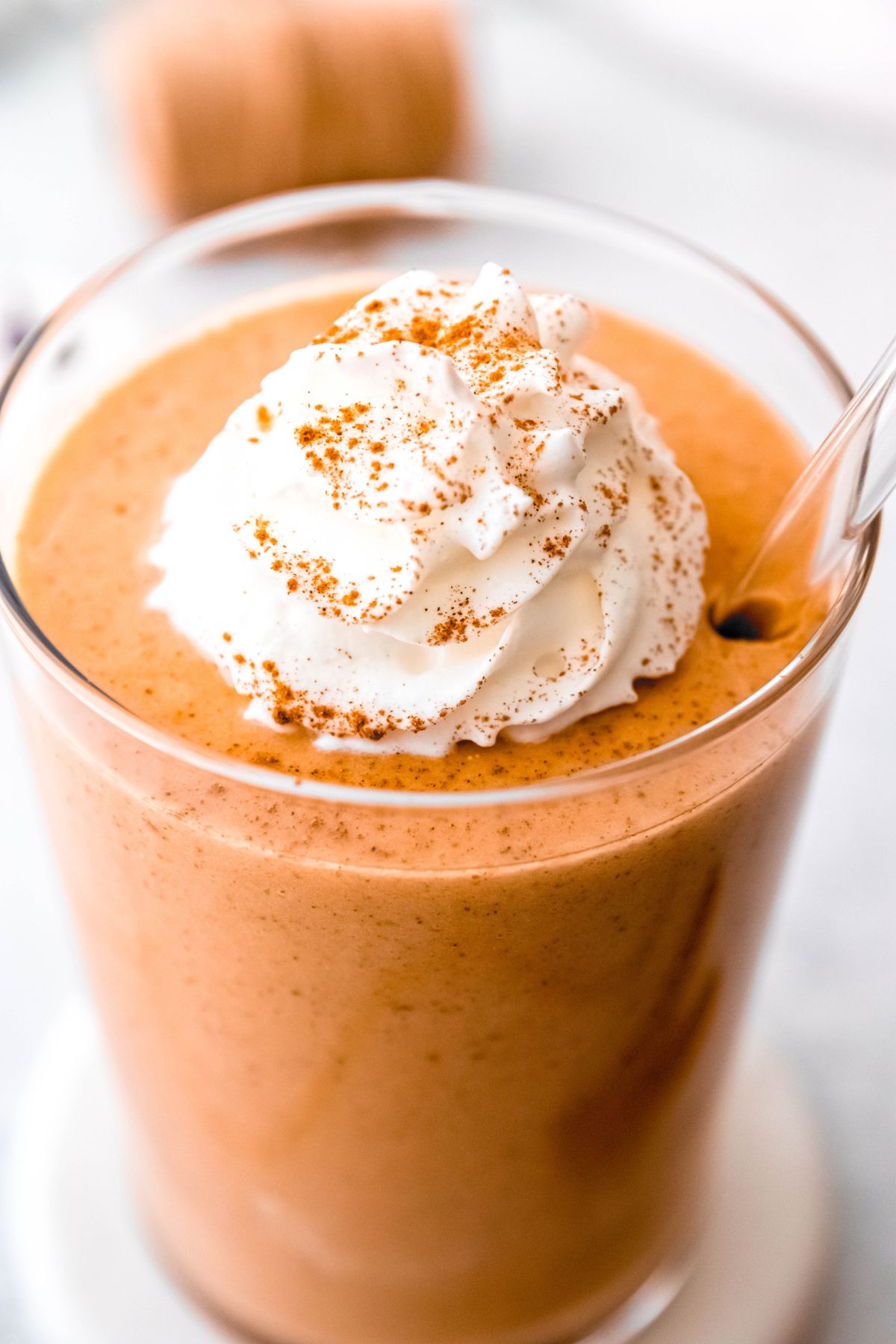 45 degree angle shot showing the top of the pumpkin protein shake topped with whipped cream and spices.