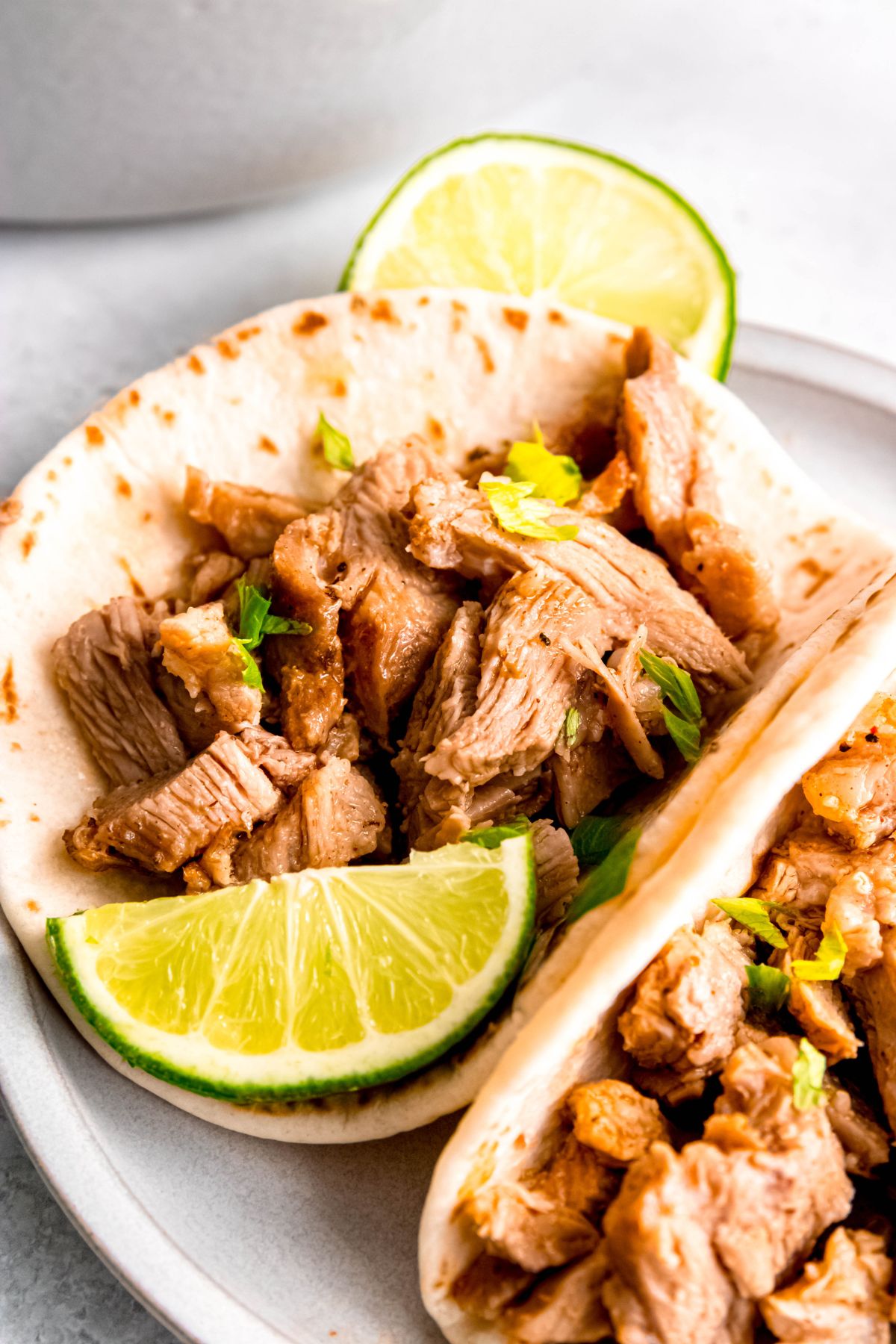 hero shot of a plate of Mexican shredded pork carnitas tacos.