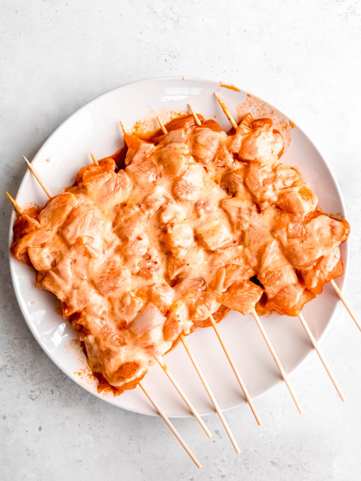 marinated chicken skewers after brushing with bang bang sauce.