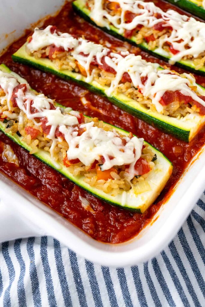 An up-close shot of Italian rice zucchini boats in marinara sauce.