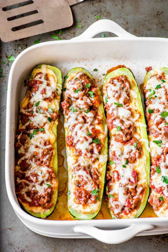 An overhead shot of a white pan of lasagna zucchini boats.