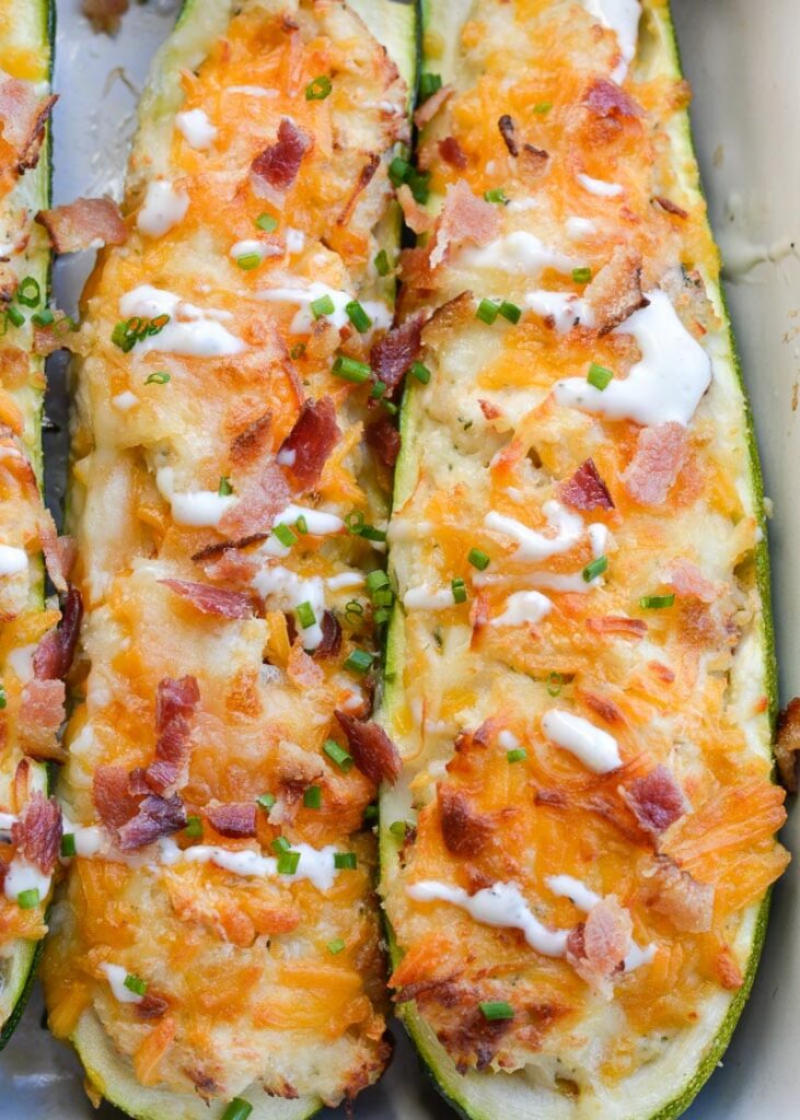 A close-up shot of two chicken bacon ranch stuffed zucchini boats.