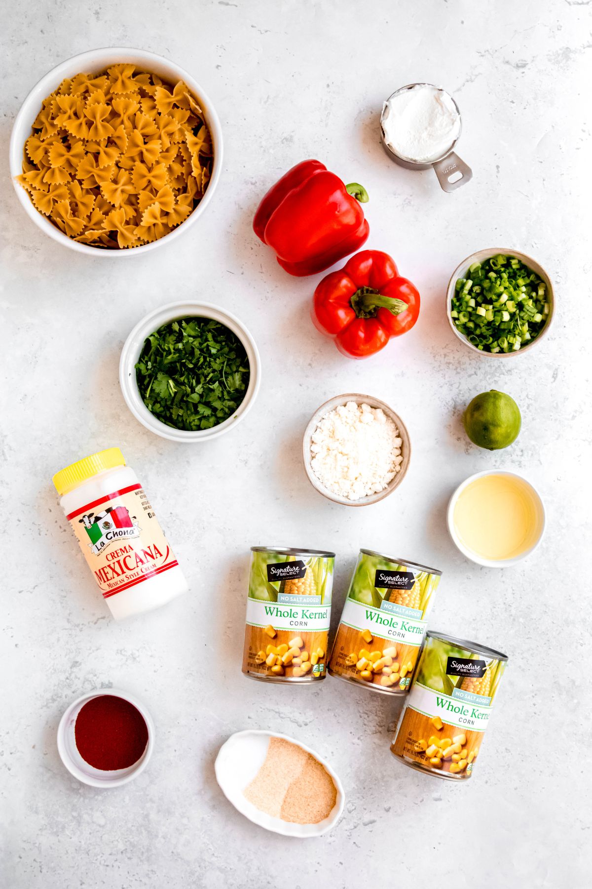 ingredients needed to make Mexican street corn (elote) pasta salad measured out on a white table.