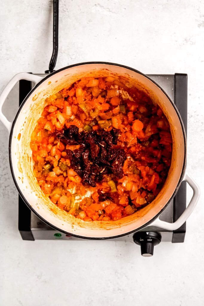 Adding the tomato paste and butter to the veggie mixture.