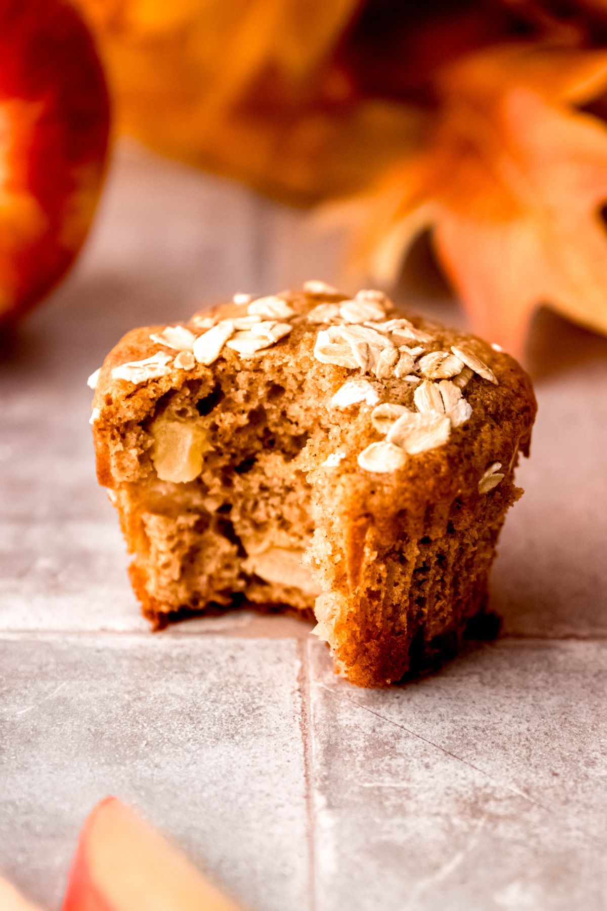 A side shot of an apple cinnamon protein muffin with a bite taken out of it.