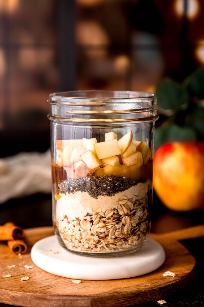 oats, protein powder, chia seeds, applesauce, cinnamon and chopped apples layered in a mason jar.