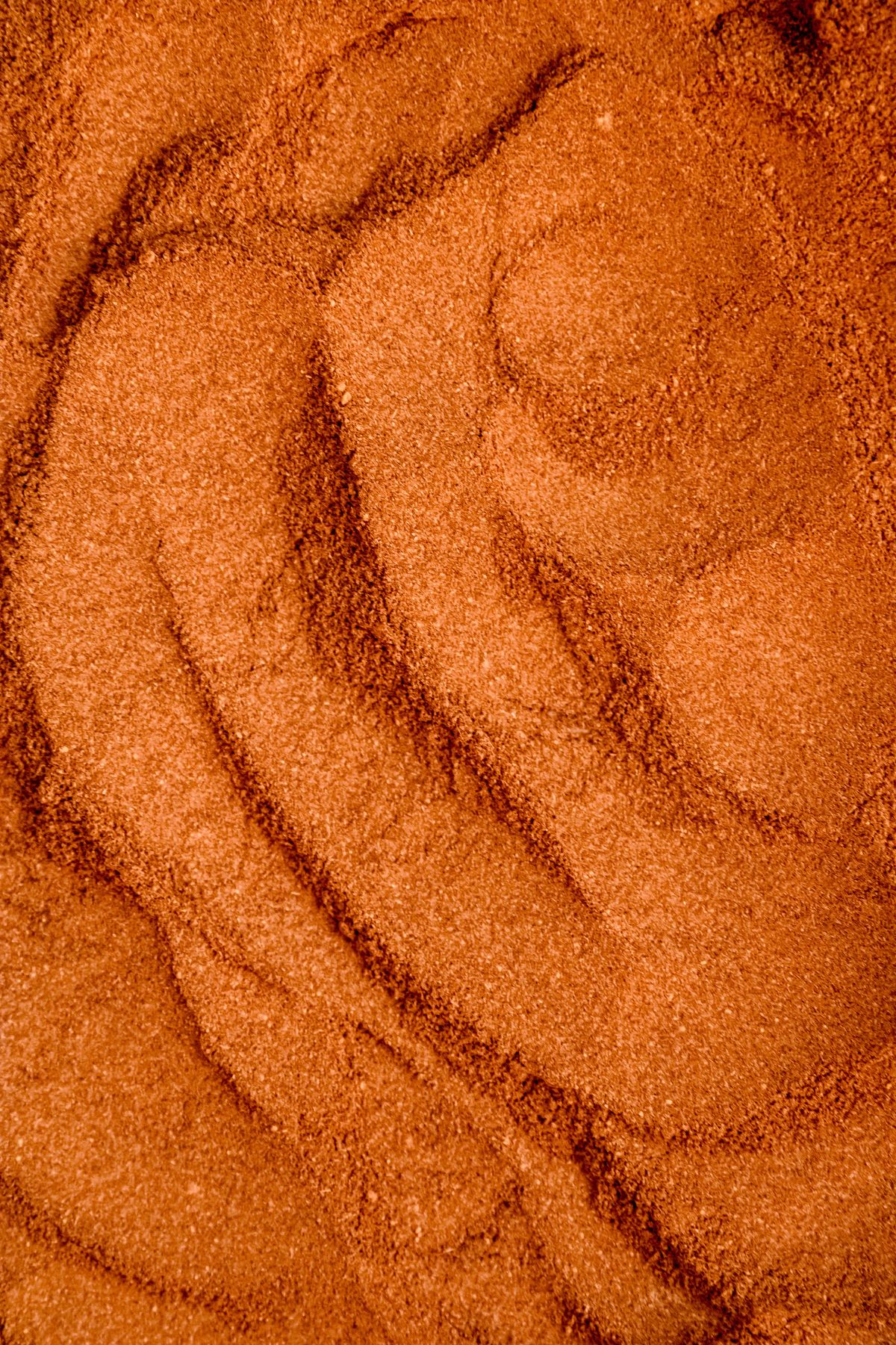 closeup shot of pumpkin pie spices mixed together with trails left behind by a spoon.