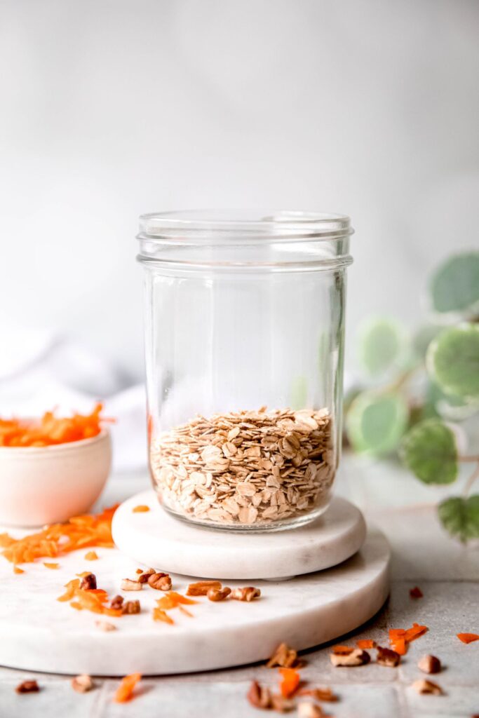 clear mason jar with rolled oats at the bottom.