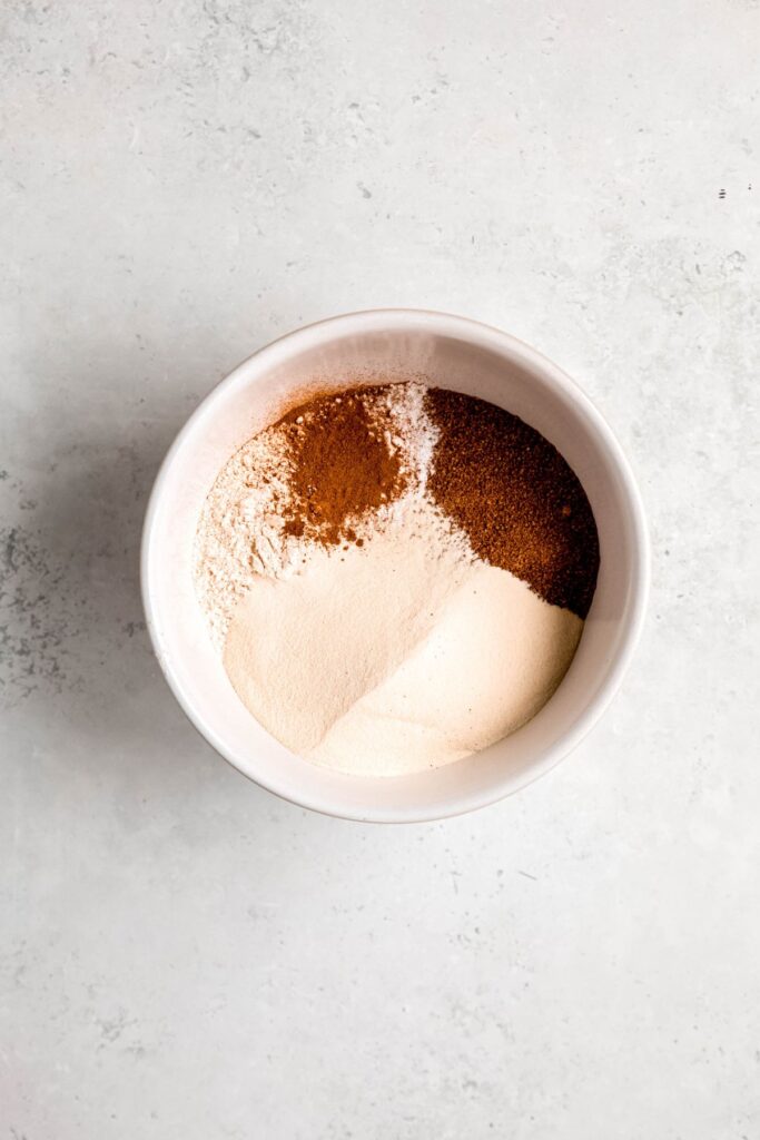 medium white mixing bowl with the dry protein powder muffin ingredients added.