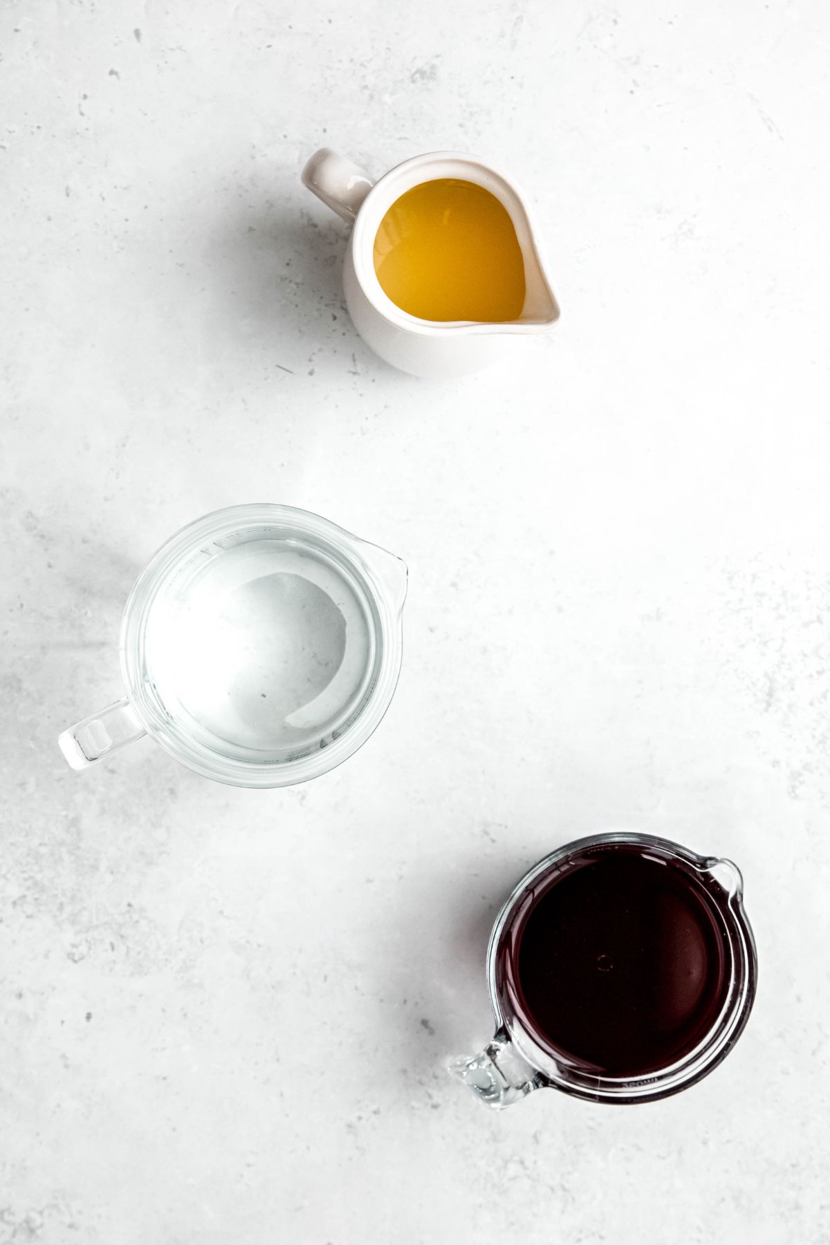 fresh lemon juice, water, and blackberry syrup measured out for making homemade blackberry lemonade.