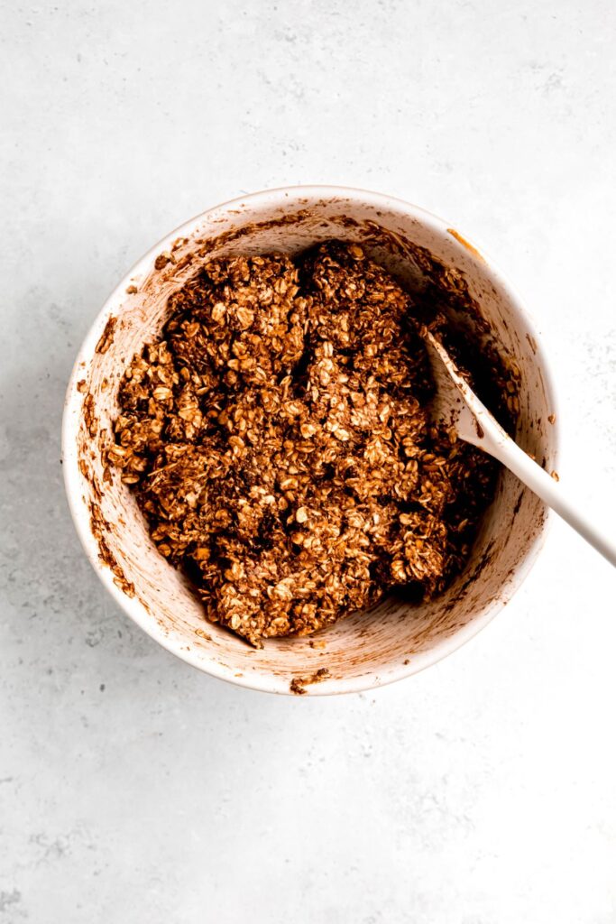 chocolate oatmeal chocolate chip protein cookie dough after stirring the ingredients together with a wooden spoon.