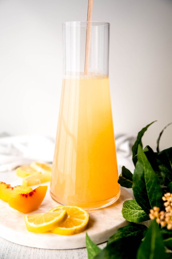 peach syrup being added to the lemon water to sweeten.