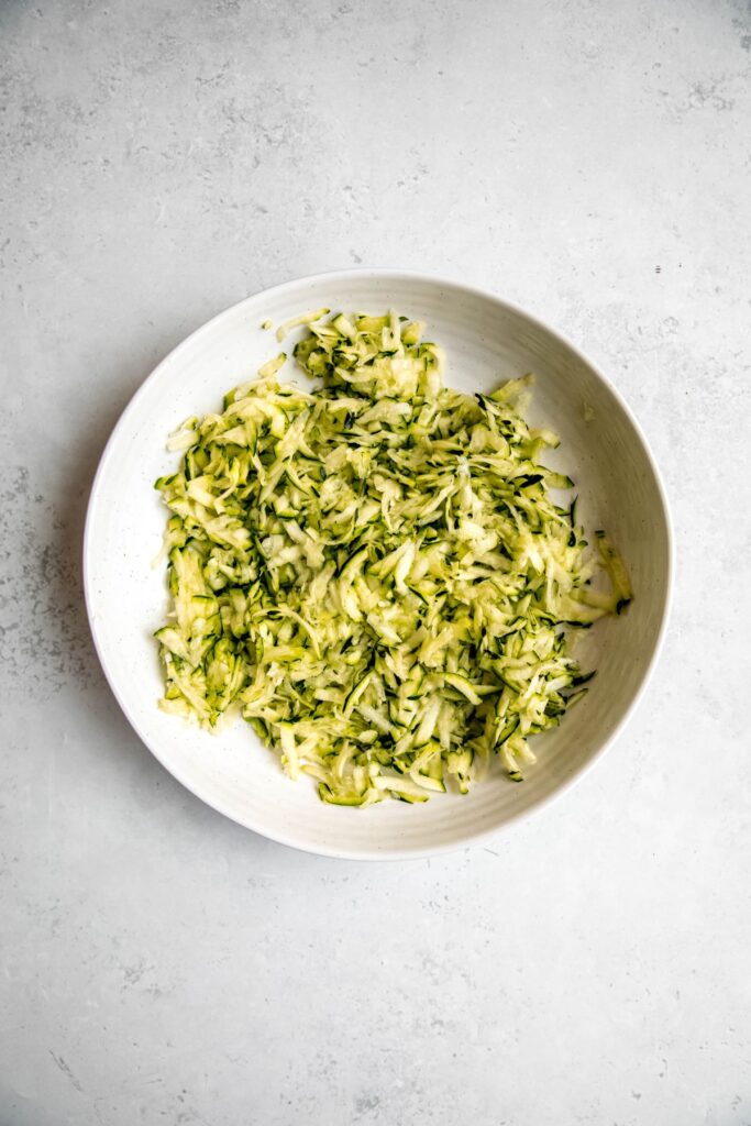 shredded and squeezed zucchini in a bowl.