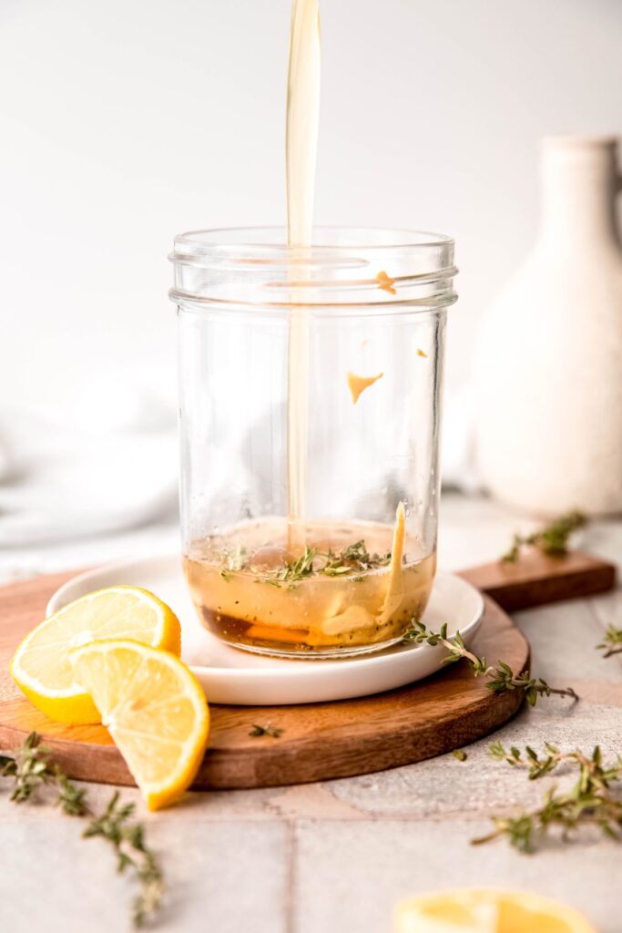 avocado oil added to the mason jar with the lemon juice, fresh thyme, and dry seasonings.