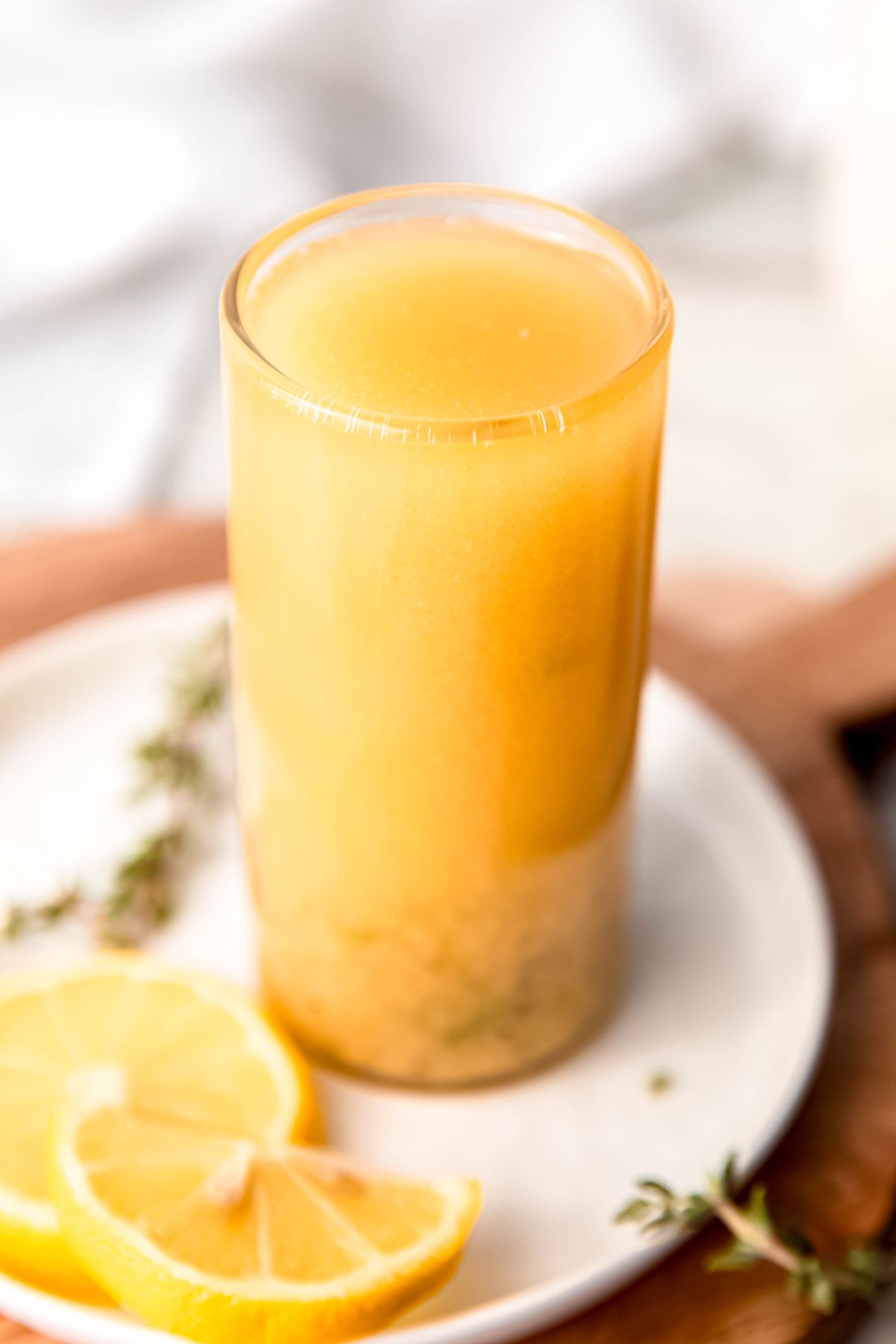 bright sunshine yellow lemon dijon vinaigrette sweetened with honey and seasoned with thyme and garlic powder in a clear glass.