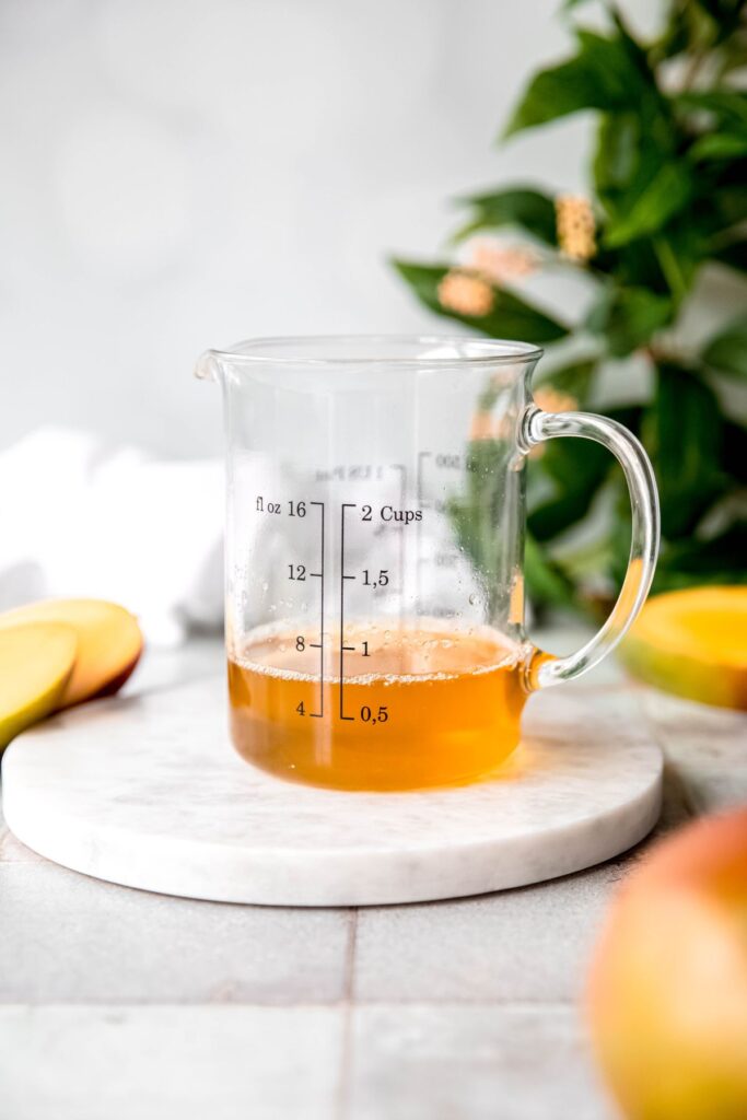 strongly brewed jasmine green tea that has been sweetened with sugar in a liquid measuring cup.