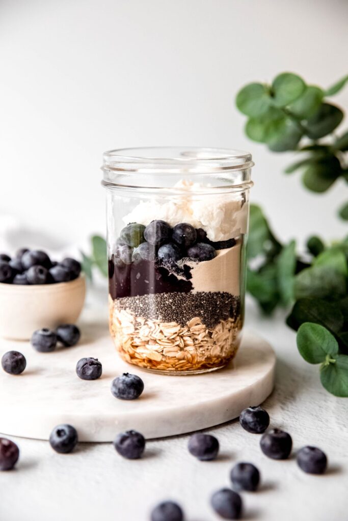 Adding all the dry ingredients to a glass jar on the counter.